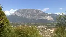 The rounded hillside of a mountain overlooking a valley.