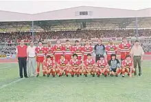 Team photo at a stadium, in front of fans in the stands