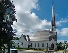 Smaller church with a steeply-pitched roof and a tall spire