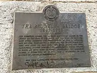 A plaque that certifies the Brooklyn Bridge as a New York City designated landmark