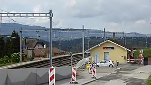 Single-story building next to double-track railway line with side platforms