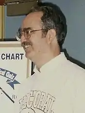 David Nolan standing next to his Nolan Chart