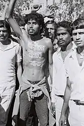 Image 35Noor Hossain, a pro-democracy demonstrator, "স্বৈরাচার নীপাত যাক//" The words, in bright white paint written on the bare chest on 10 November 1987 protest for democracy in Dhaka, photographed by Dinu Alam just before he was shot dead by President Ershad's security forces (from History of Bangladesh)