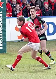 Ronan O'Gara playing for Munster and passing the ball to a teammate in 2013