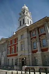 A red brick building with white stone detailing in the Queen Anne style with French influences