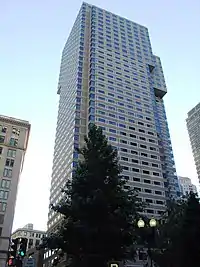 Ground-level view of a 40-story skyscraper with a tan facade; minor setbacks are visible around the tower's 30th floor