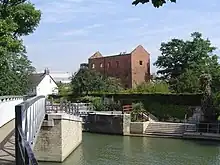 The derelict Osney Mill buildings off Mill Street to the west, with Osney Lock in the foreground.