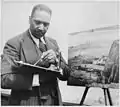 Painter Palmer Hayden working on a landscape, n.d.