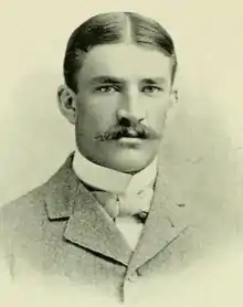 A man with a large mustache and nice jacket posing for a picture