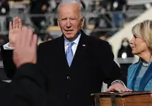 Photo of Biden raising his right hand, with his left hand placed on a thick Bible