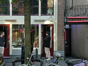 Image 5A prostitute in Amsterdam's red-light district talks with a potential customer. (from Prostitution)