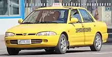 A Proton Wira yellow taxi in Pyongyang.