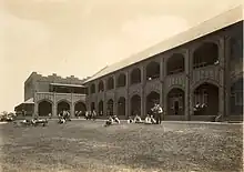 Large school surrounded by girls playing on huge lawned campus