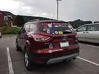 A Ford Escape with bumper stickers.