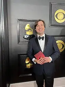 Repper, in blue tuxedo, smiling at the 2023 Grammy Awards Red Carpet