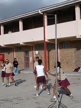 Coloured girls playing netball on an outside court