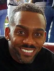 Man in a black jumper smiling for the camera