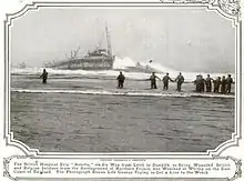 Black and white photo of a ship sinking into the water, with multiple people running towards it.