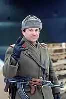 A Romanian sub-officer gives the victory sign on New Year's Eve 1989. He has removed the insignia of communist Romania from his ushanka.