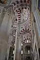 Details in the pillars of mosque, including red and white ablaq in the arches and muqarnas on the pillars and on the pendentives