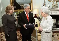 Color image of Chilean President Sebastián Piñera and First Lady Cecilia Morel presenting a souvenir gift rock from the San Jose Mine to Queen Elizabeth II on 18 October 2010 during a state visit to the UK