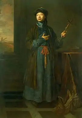 A full length portrait of a man wearing a long green robe and holding a crucifix.