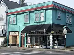 Photograph of a two-story building at the intersection of two streets