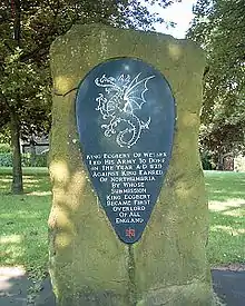 Photograph showing a rough hewn stone covered with lichen. Mounted on the stone there is an oval tablet carved with a dragon. The text reads King Ecgbert of Wessex led his army to Dore in the year A-D 829 against King Eanred of Nothumbria by whose submission King Ecgbert became first overlord of all England.