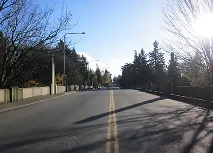 A street-level view of 15th Avenue NE as it continues along the Cowen Park Bridge.