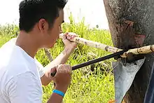 Photo of man holding bar that penetrates large tank