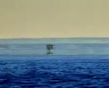 In this mirage, at least three separate images of a boat are visible. The real one at the bottom and the uppermost one are in the upright position, whereas the one in the middle is inverted