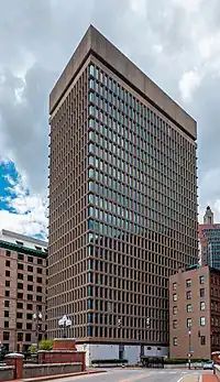 A tan-color 23-story office building in a dense downtown area