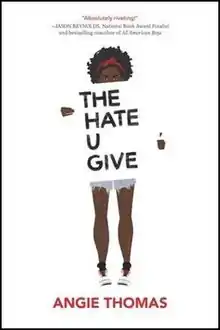 Cover art for the novel The Hate U Give, published in 2017. The cover art depicts a young African-American female teenager holding a title card with the novel's title; the title card obscures the entirety of the teenager's torso, and the only visible clothing includes a red hairband, blue denim cut-off shorts, and white athletic shoes.