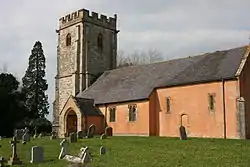 Red stone building with grey square tower.