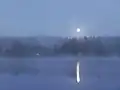 Moonlight illuminates a lake and surroundings.