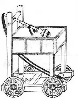 An ink on paper diagram of a trebuchet. A long arm with a spherical cap rests on top of a large square platform. The square platform is supported by four plain cut square beams, which connect to an open undercarriage. Rope hangs between the end of the pole that does not have the cap to the inside of the undercarriage, as far away from the start of the rope as possible. The assembly moves on four wheels attached to the sides of the undercarriage.