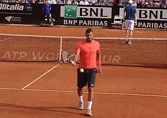 Tsonga in a blue shirt looking away from the camera.