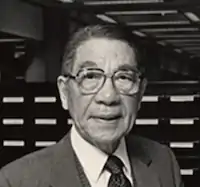 an older chinese man with glasses in a close headshot