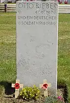 A single marker for two of the four German graves at Tyne Cot. One soldier is named, the other is unknown.