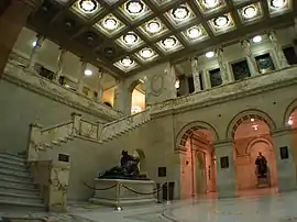 Marble lobby with statues, columns and a flight of steps