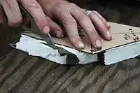 A Marine shapes a charge of C4 to cut through solid steel at a demolitions range