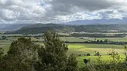 green fields and green hills in the distance