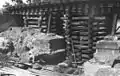 Underpinning the foundations of a railway bridge using a timber box crib to support the bridge.  A completed concrete pad underpinning can be seen at the bottom right.]