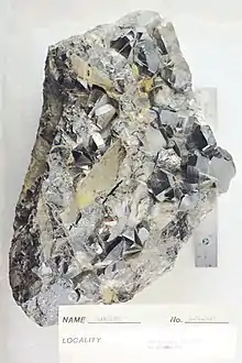 A black and silver-coloured rock with protruding crystals appearing with 4, 5 and 6 sides