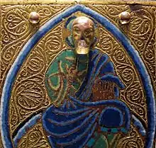 Detail from 13th century Limoges chasse, with a projecting modelled head on a flat background.