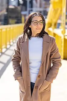 Photo of Virginia Montanez standing on yellow bridge in Pittsburgh, PA