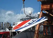 The tail fin of the Airbus A330 that crashed as Air France Flight 447 is being loaded onto the frigate