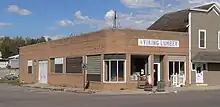 One-story brick building with rounded corners, probably dating from the 1940s or early 1950s; "Viking Lumber" sign with profile head of Viking