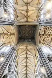 A view looking directly up at a very high, coloured, patterned ceiling.