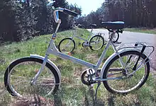 A white bicycle parked in the grass.